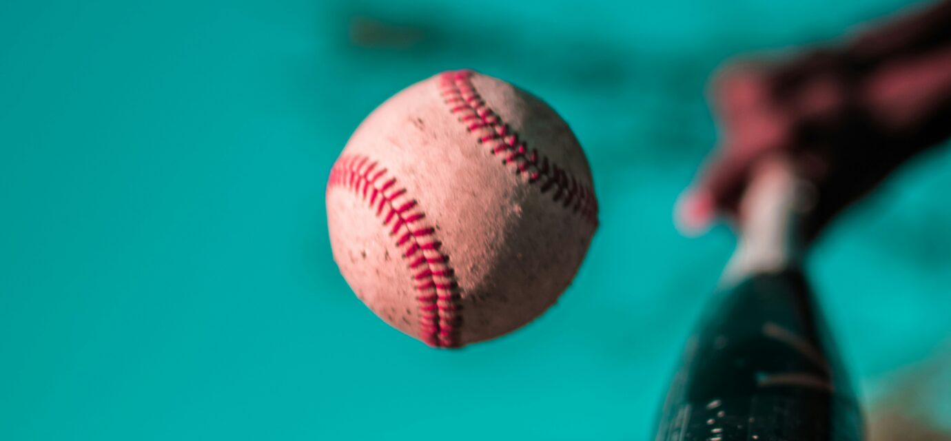 A baseball bat connects with a baseball.