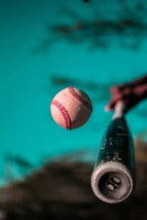 A baseball bat connects with a baseball.
