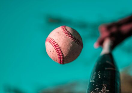 A baseball bat connects with a baseball.