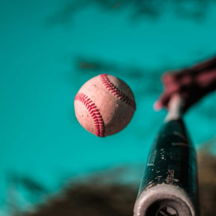 A baseball bat connects with a baseball.