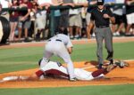 A baseball player slides into base and is tagged out.