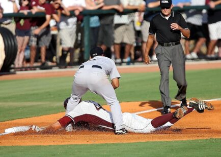 A baseball player slides into base and is tagged out.