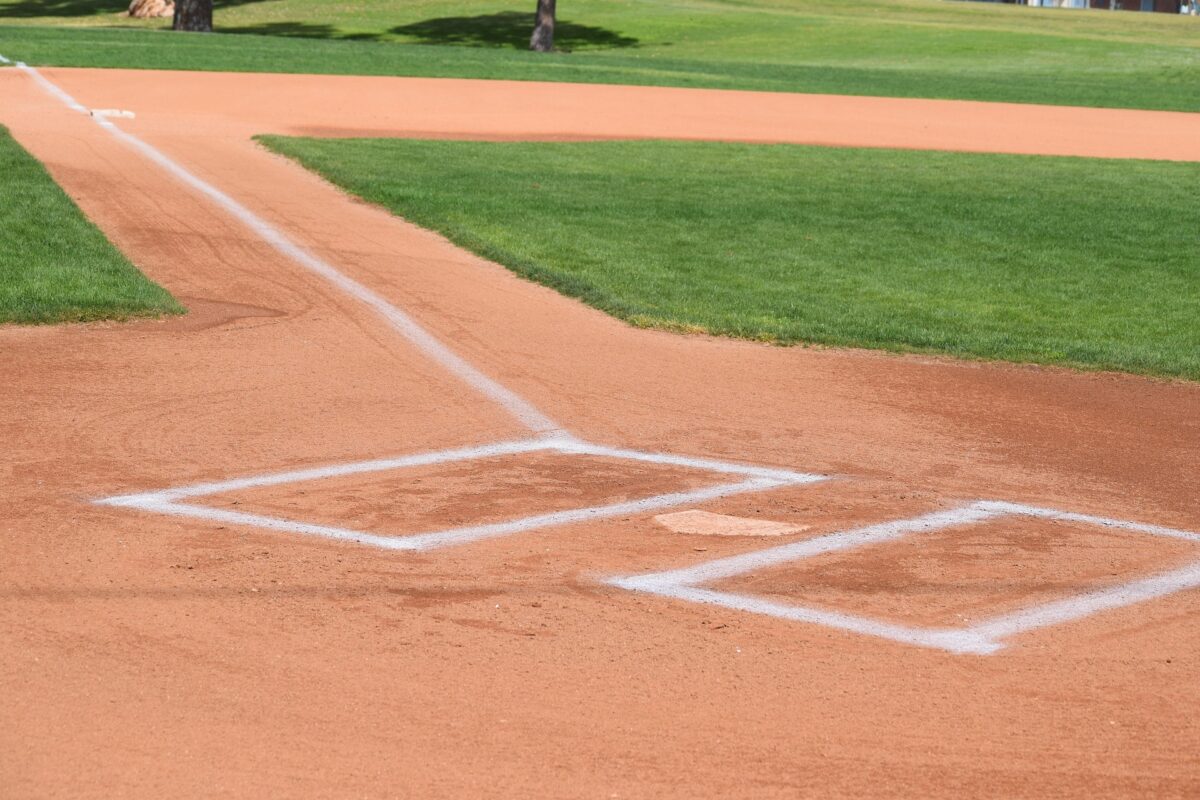 Home plate and batter's boxes on a freshly groomed baseball field.
