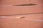 Baseball diamond with third base in the foreground and the pitcher’s mound in the distance.