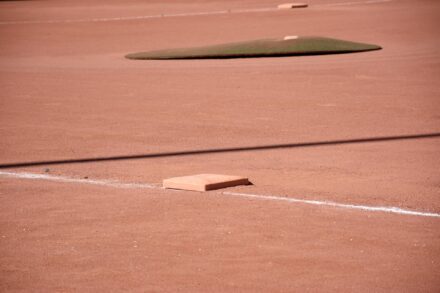 Baseball diamond with third base in the foreground and the pitcher’s mound in the distance.