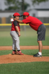 A baseball coach gives a player a pep talk.