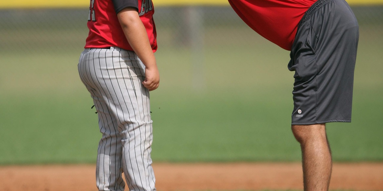 A baseball coach gives a player a pep talk.
