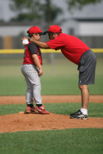 A baseball coach gives a player a pep talk.