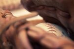 Close up view of a baseball inside a baseball glove.