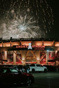 Nighttime view of Angels Stadium in Anaheim, CA, with fireworks in the background.