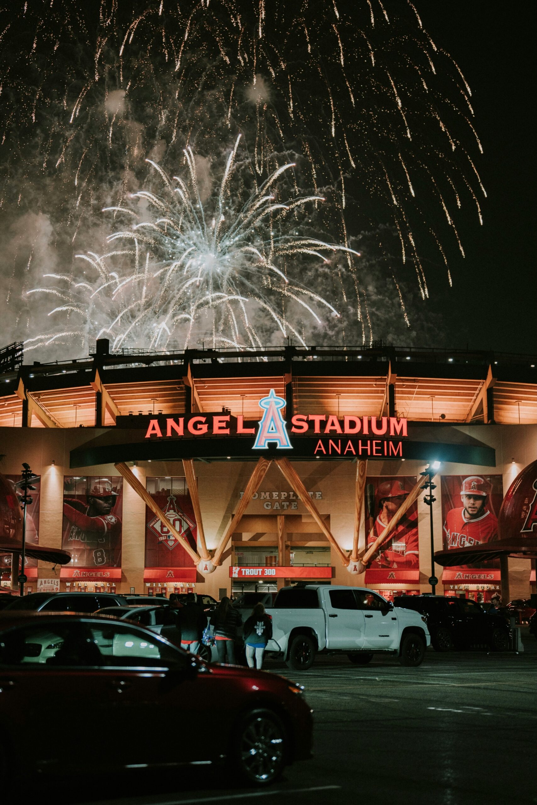 Nighttime view of Angels Stadium in Anaheim, CA, with fireworks in the background.