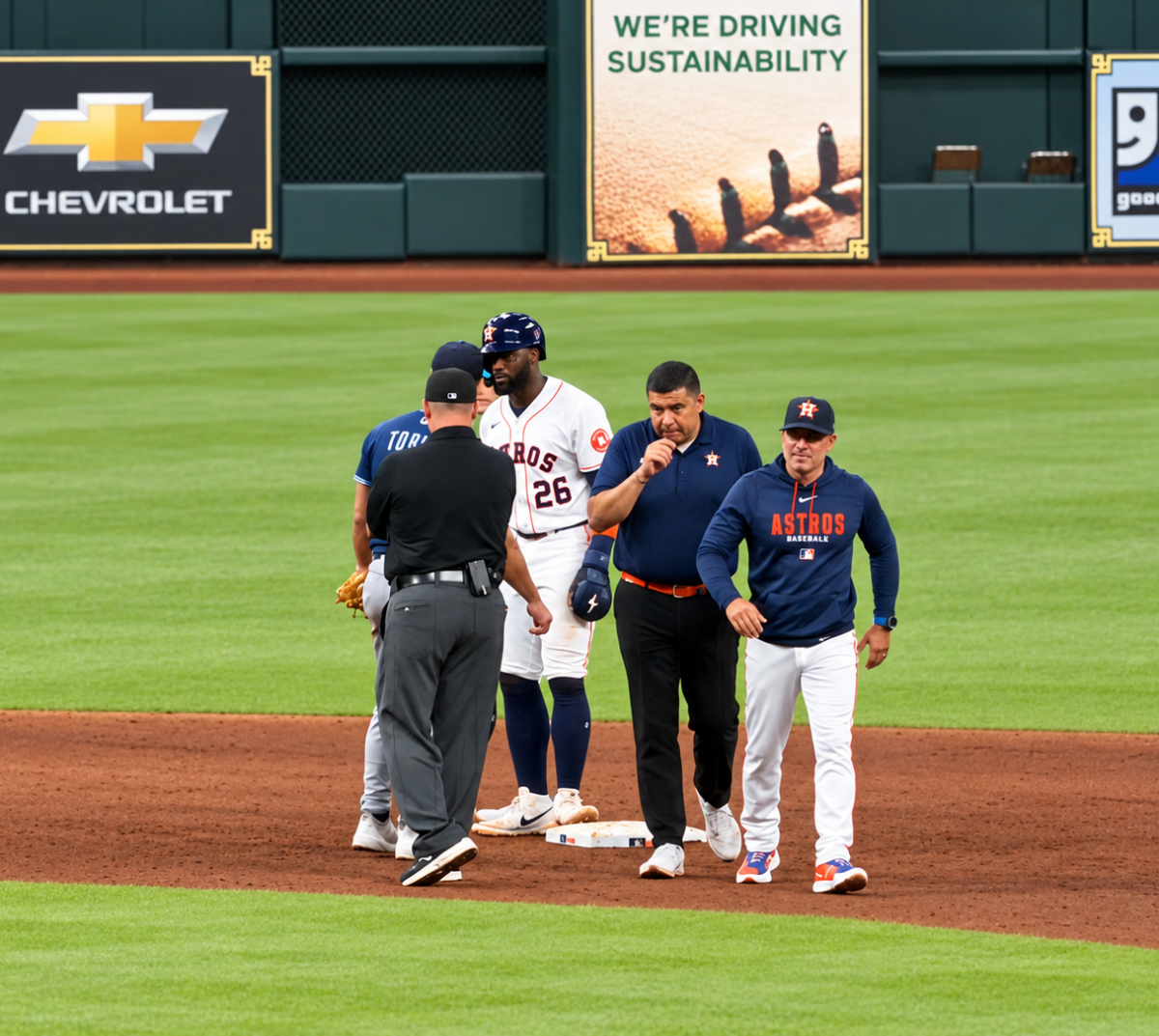 Houston Astros manager Joe Espada walks away from a mound visit near second base at Daikin Park, with players, a coach, and an umpire gathered on the infield.