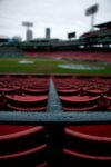 Baseball stadium seats and railing covered in rain.