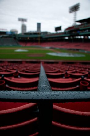 Baseball stadium seats and railing covered in rain.